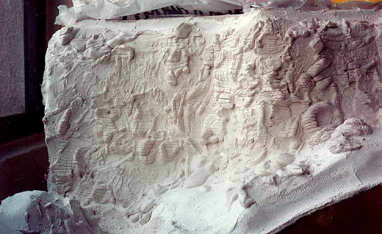 O gesso do relevo da maquete deve ser riscado e escovado antes de secar, para criar a paisagem de uma região semi-árida